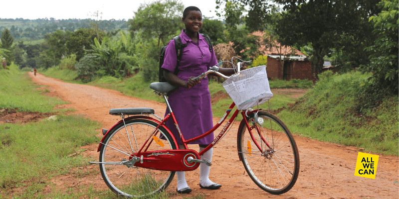 Nawalat stands by her bicycle in Uganda