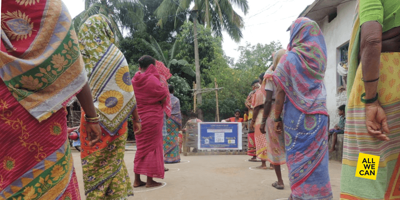 Women line up, socially distanced, to receive food and hygiene supplies during India's first Covid-19 wave.